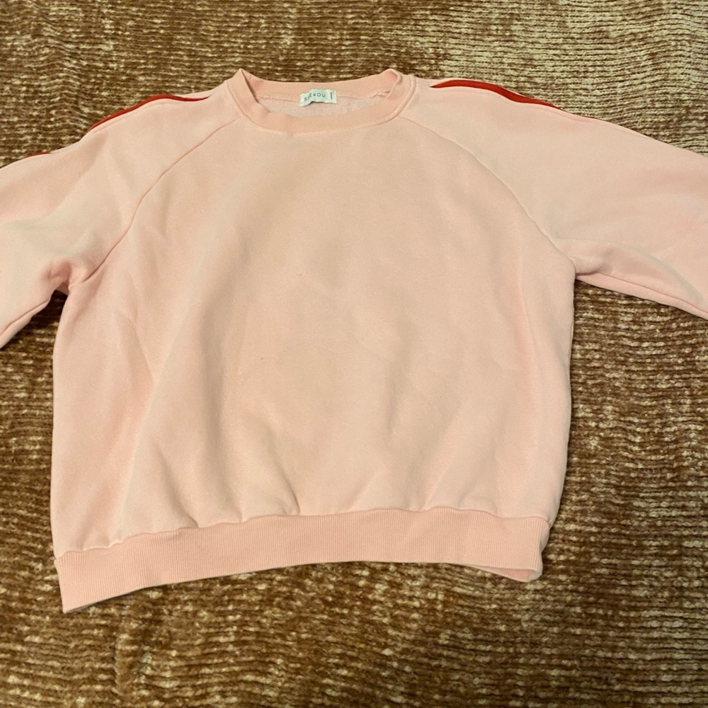 Pink crew neck with red zippers on the arms